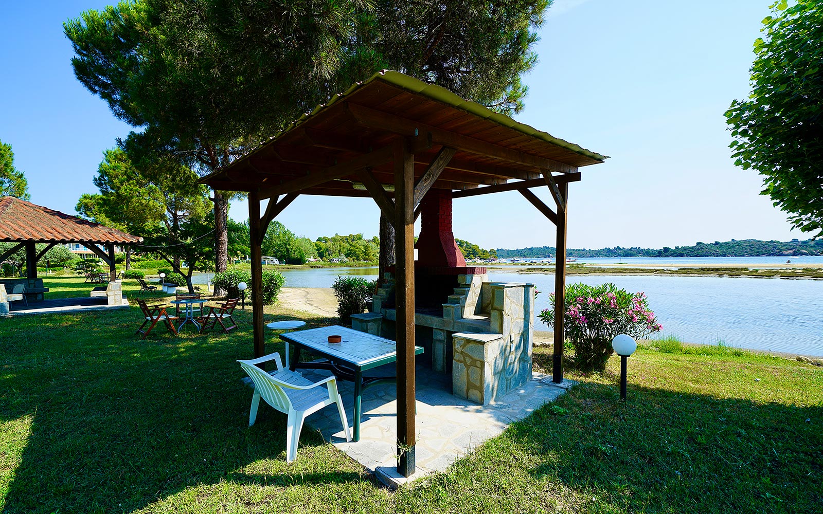 Χώρος barbecue με σκιερό καθιστικό και θέα στη θάλασσα στο Bloomora.