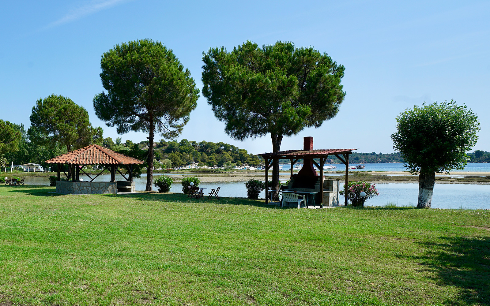 Garden barbecue area and shaded kiosk by the water at Bloomora.