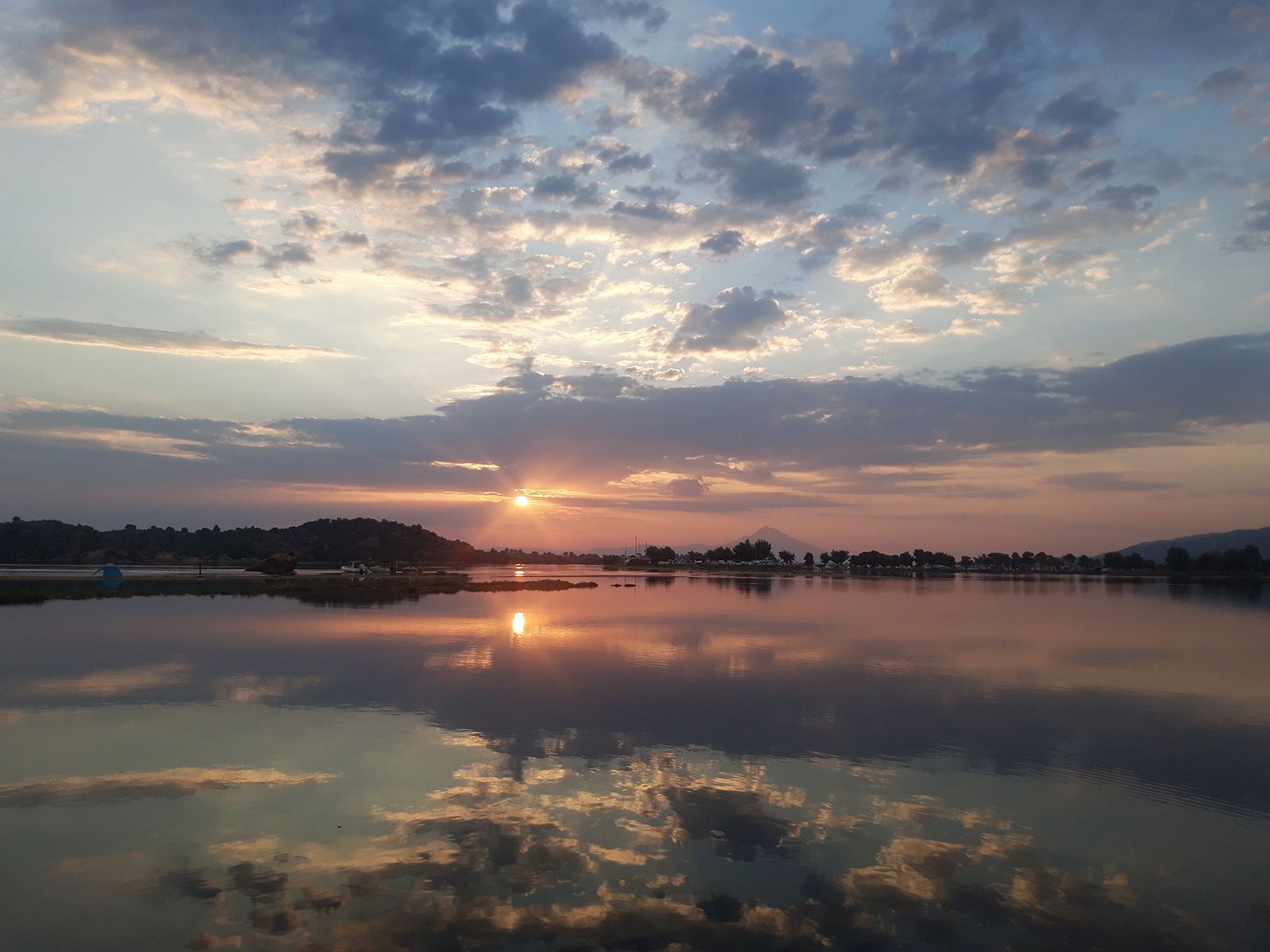 Sunrise reflections on calm water near Bloomora.