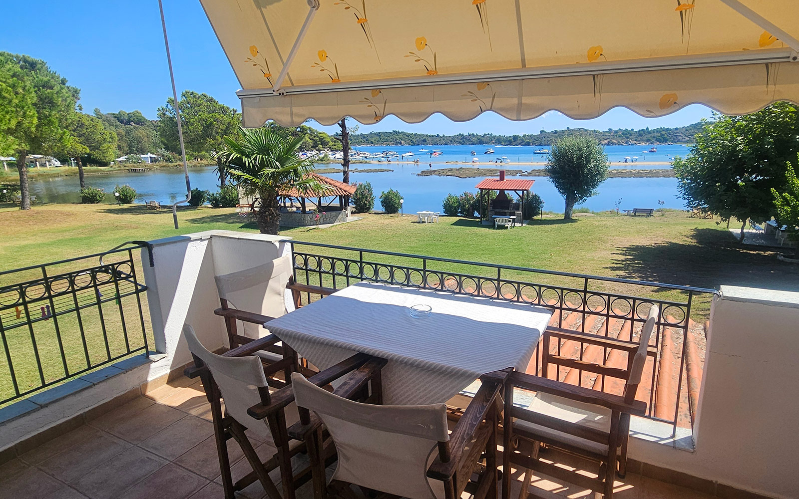 Balcony with table, chairs, garden and sea view from Classic Studio No23 at Bloomora.
