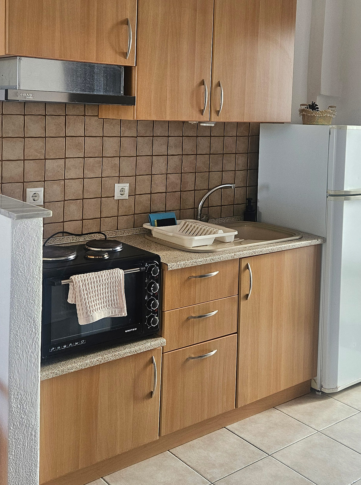 Kitchenette with refrigerator, sink, cabinets and cooking area in Classic Studio No23.