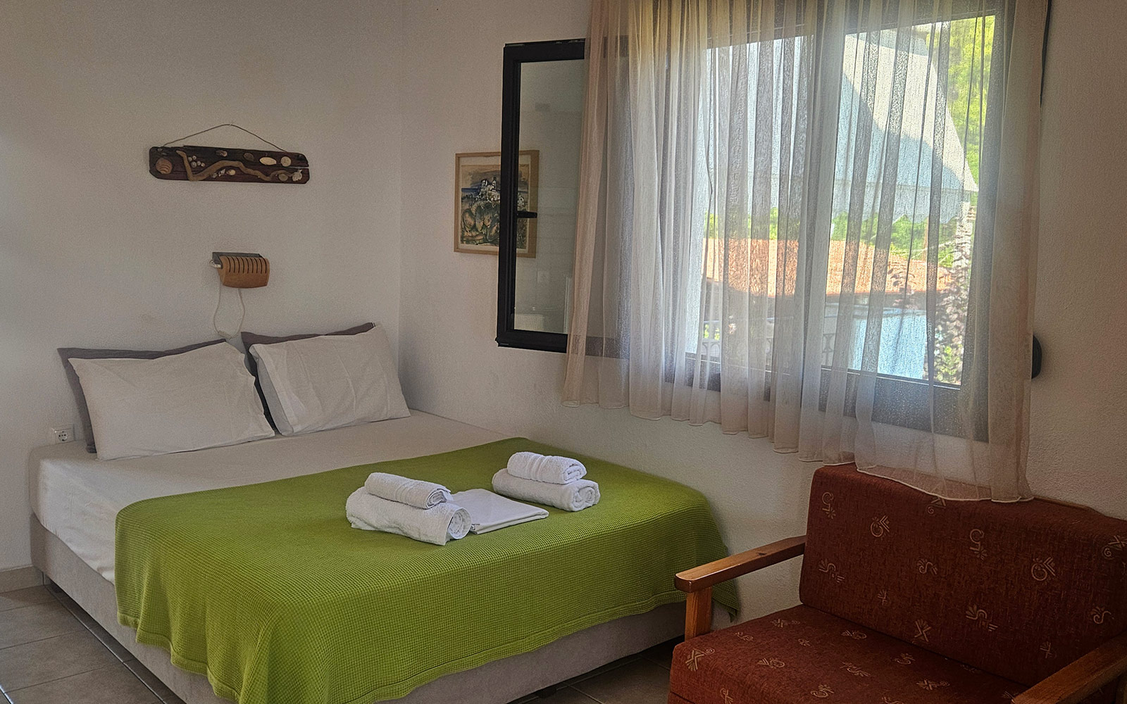 Sleeping area with double bed, sofa and soft natural light in Classic Studio No23.