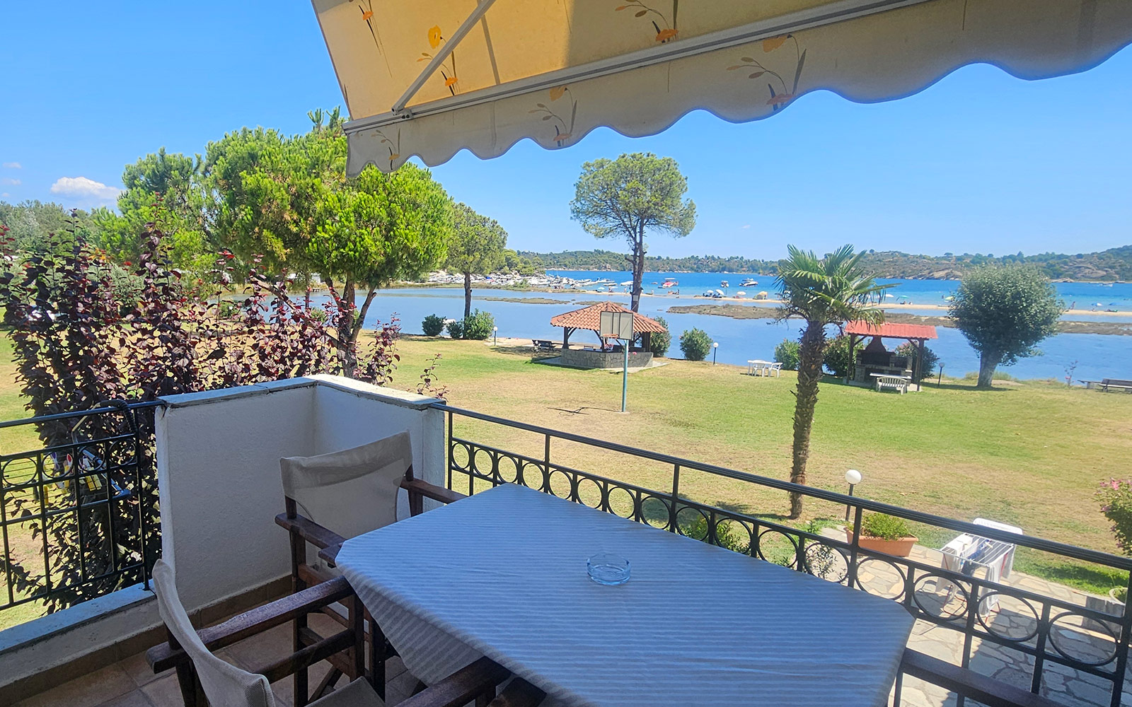 Balcony with table, chairs, garden and sea view from Classic Studio No24 at Bloomora.