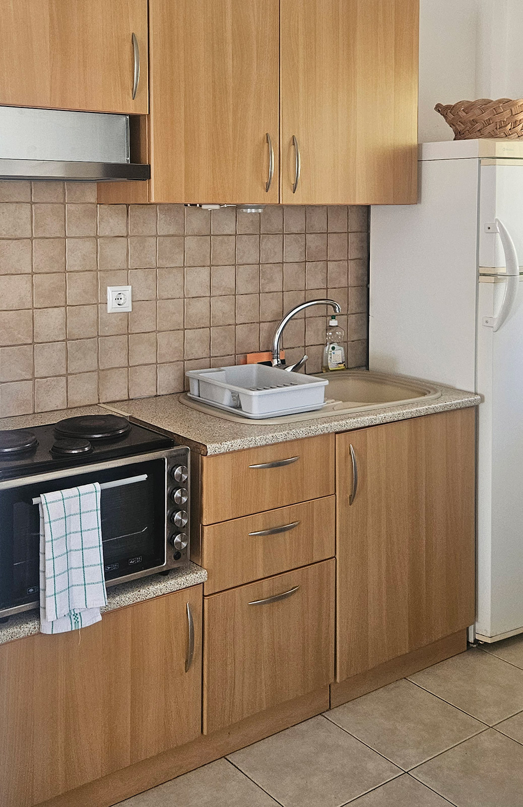 Kitchenette with refrigerator, sink, cabinets and cooking area in Classic Studio No24.