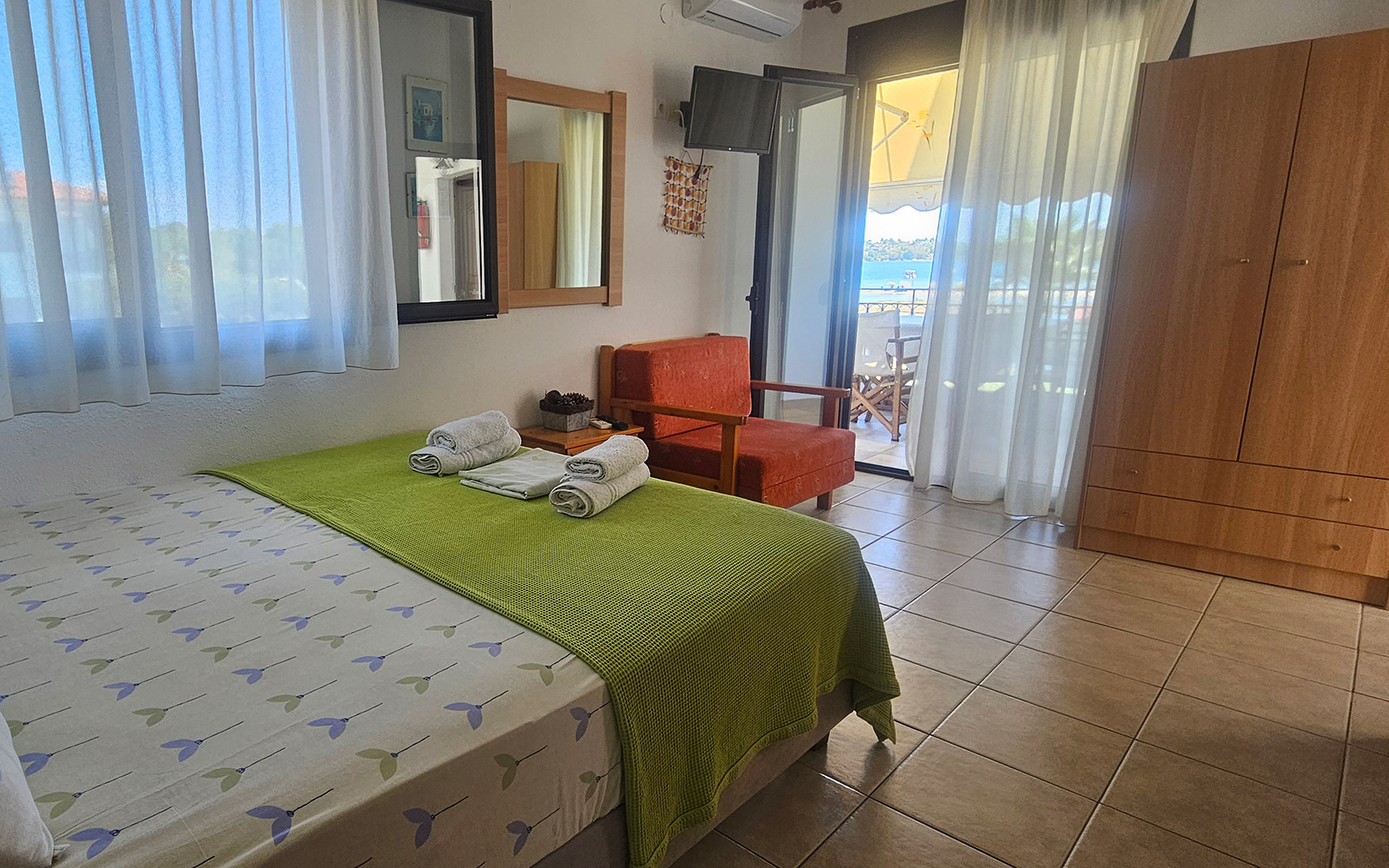 Open-plan room with double bed, seating, wardrobe and balcony access in Classic Studio No24.