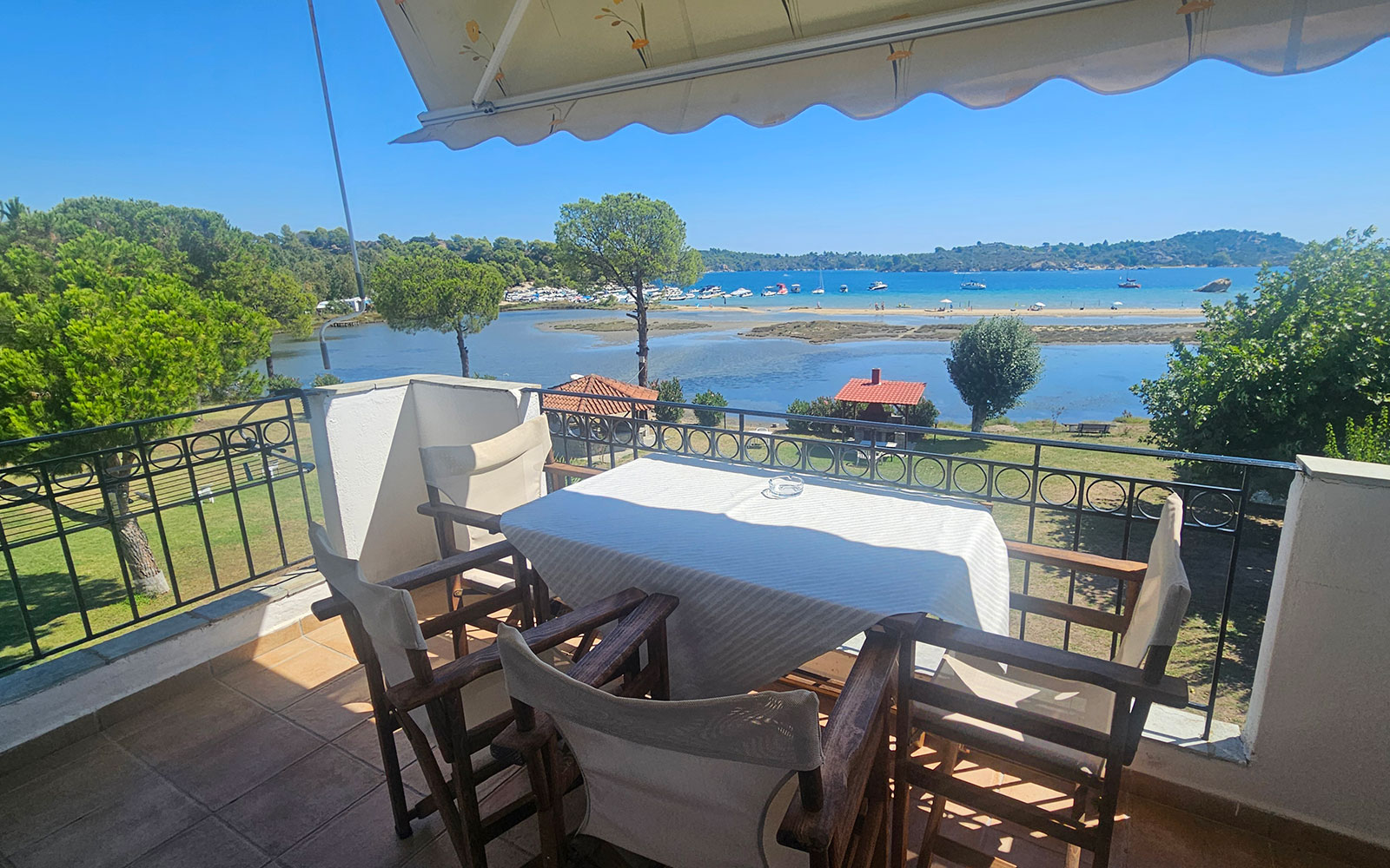 Balcony with table, chairs, garden and sea view from Classic Studio No33 at Bloomora.