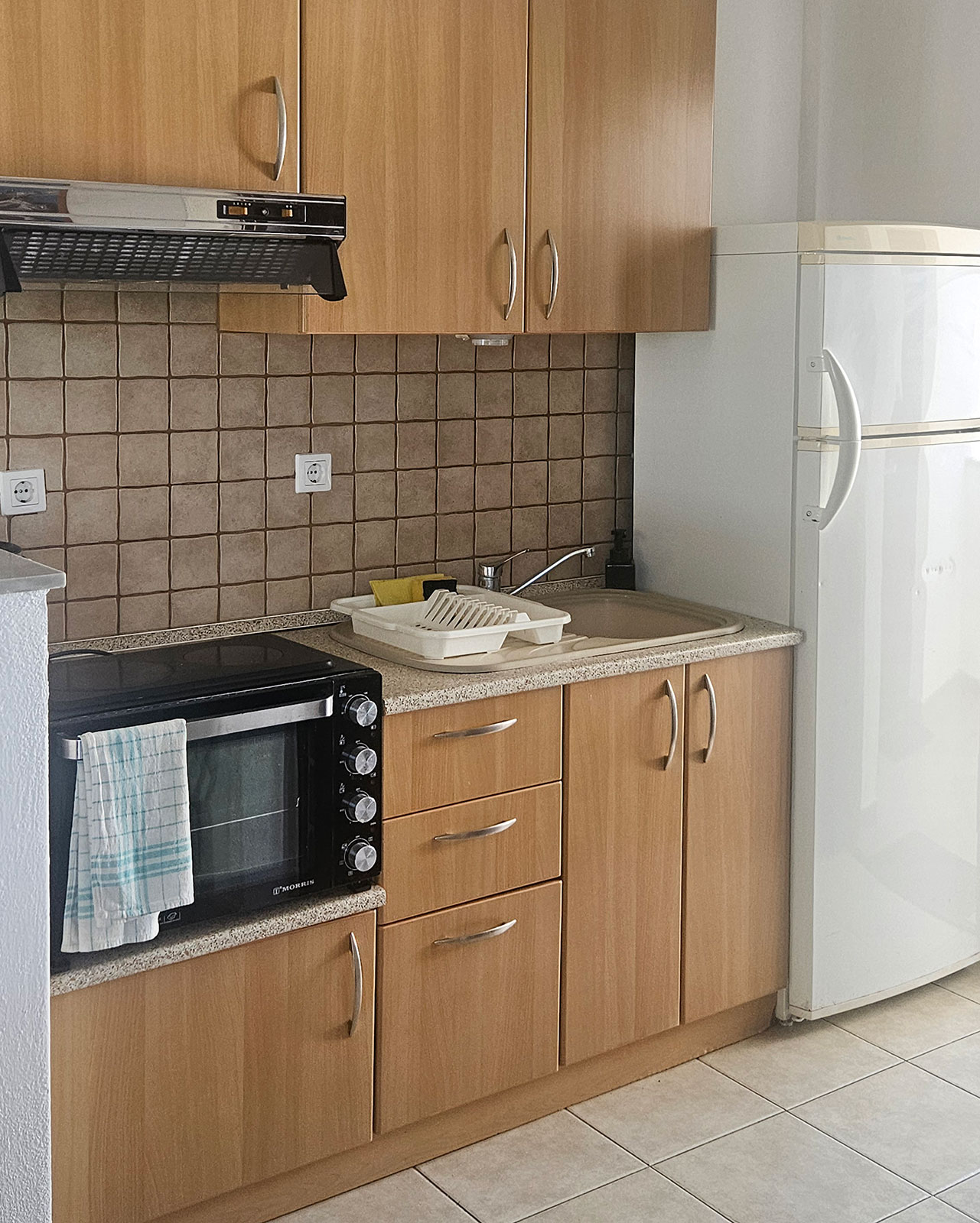 Kitchenette with refrigerator, sink, cabinets and cooking area in Classic Studio No33.