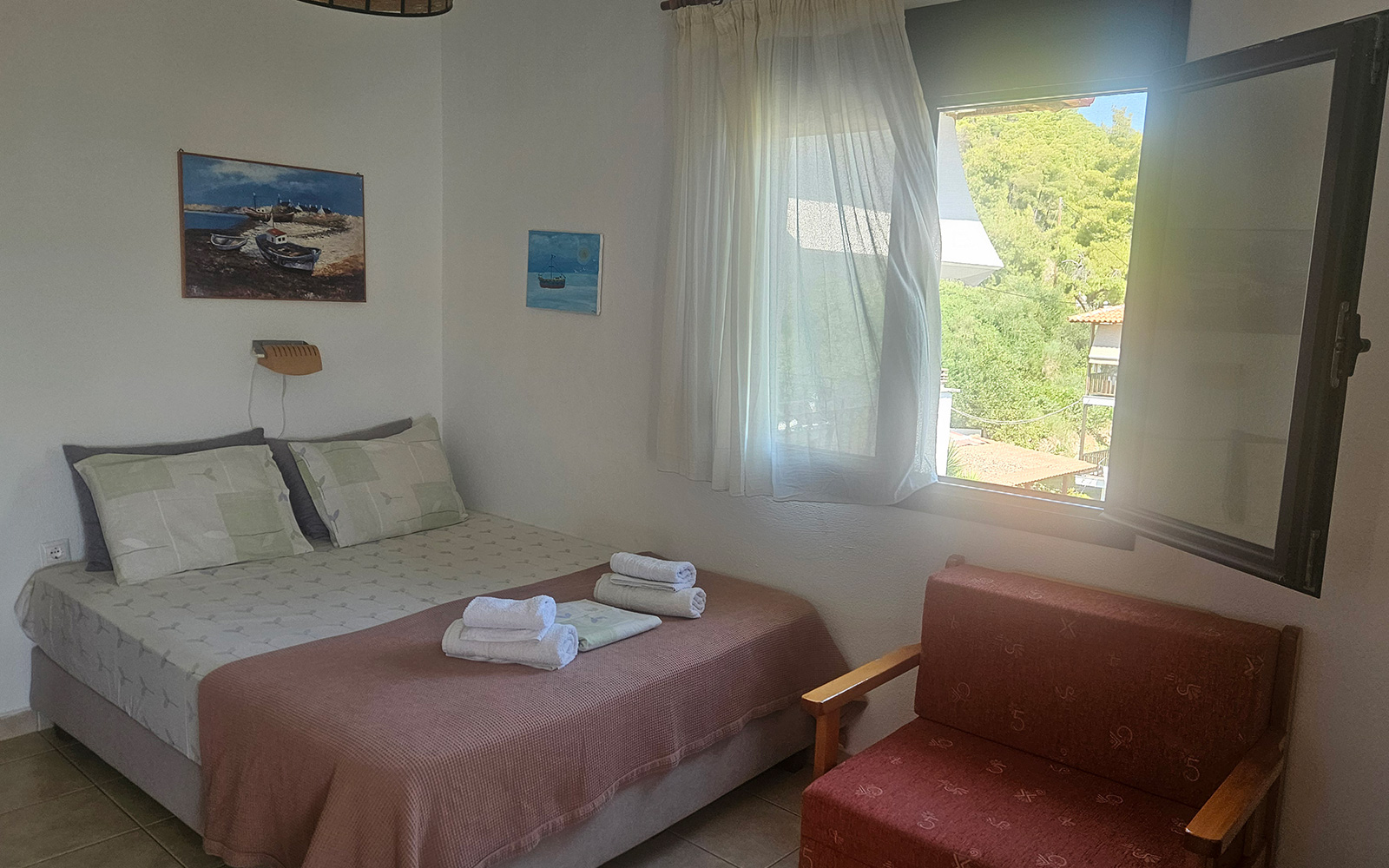 Sleeping area with double bed, seating and soft natural light in Classic Studio No33.