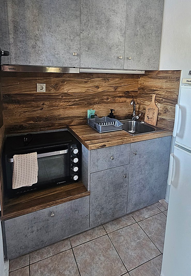 Kitchenette with cooking area and refrigerator in Junior Studio No04 at Bloomora.