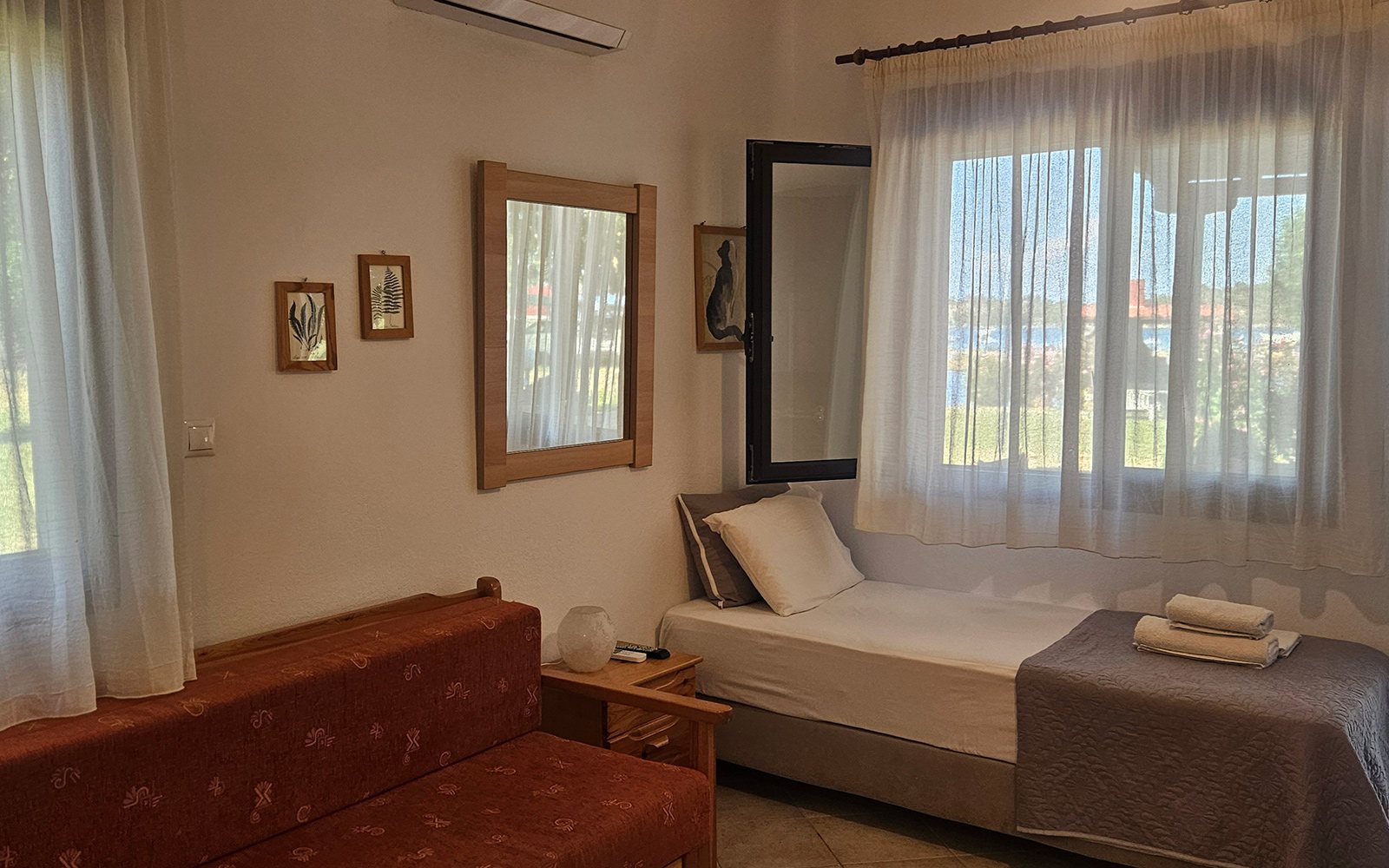 Living area with sofa and single bed in Terrace Studio No13 at Bloomora.