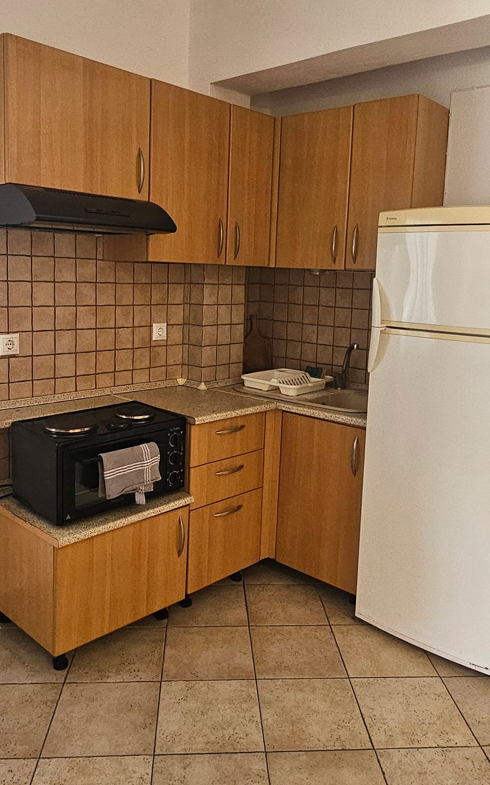 Kitchenette with cooking area and refrigerator in Terrace Studio No14 at Bloomora.